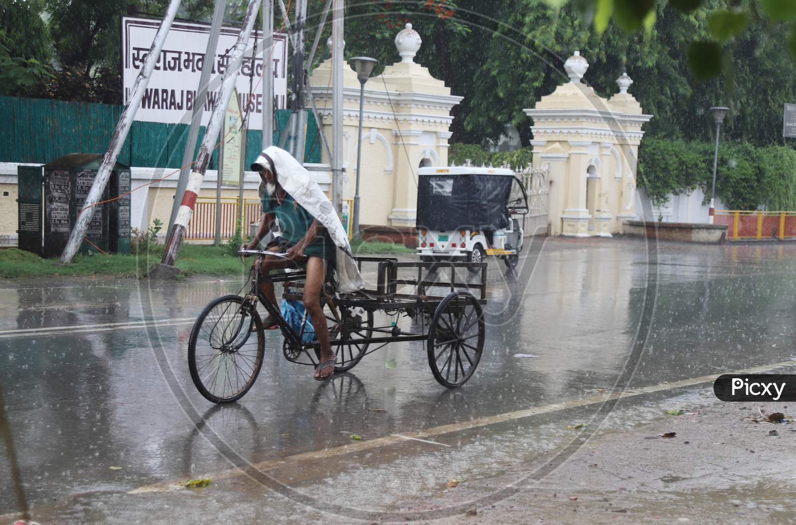 A Man Pedals his Trolly On The Road During a Heavy Pre Monsoon Rain In Prayagraj, June 17, 2020.
