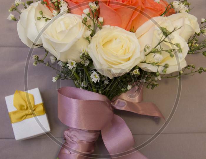 Bouquet Of White And Orange Roses Wrapped By Purple Satin Bow