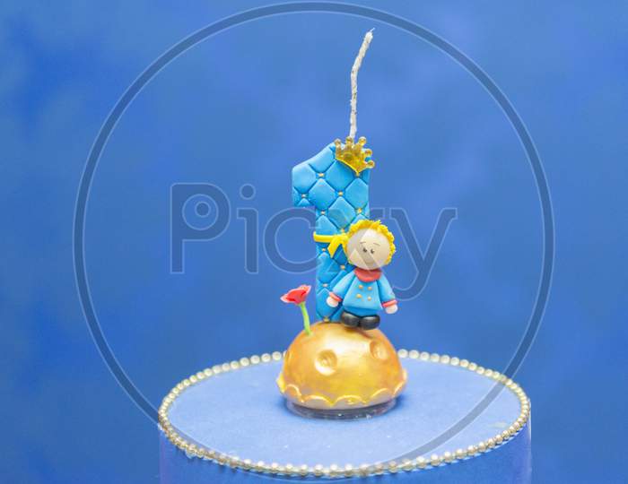 Number One Candle On A Blue Background. Little Prince Theme. Fake Birthday Cake With Personalized Candle For First Birthday For Boy.