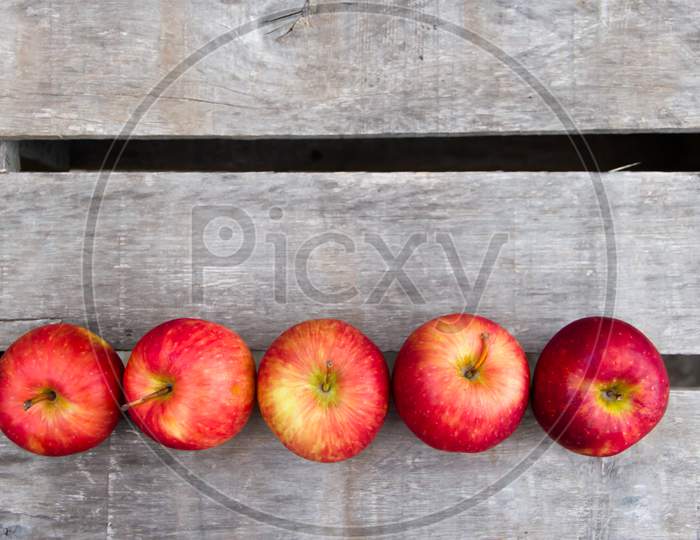 Red Apples On Rustic Wooden Background