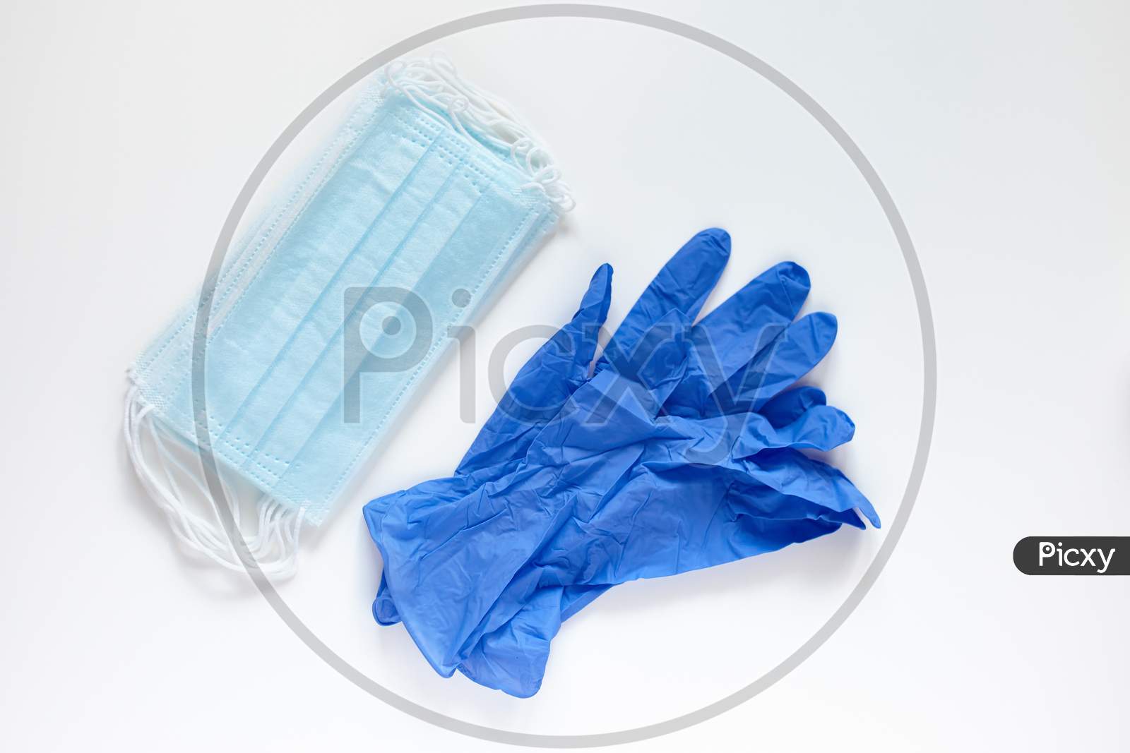 Pair Of Latex Medical Gloves And Surgical Ear-Loop Masks On White Background. Protection Concept. Coronavirus Covid-19 Pandemic.