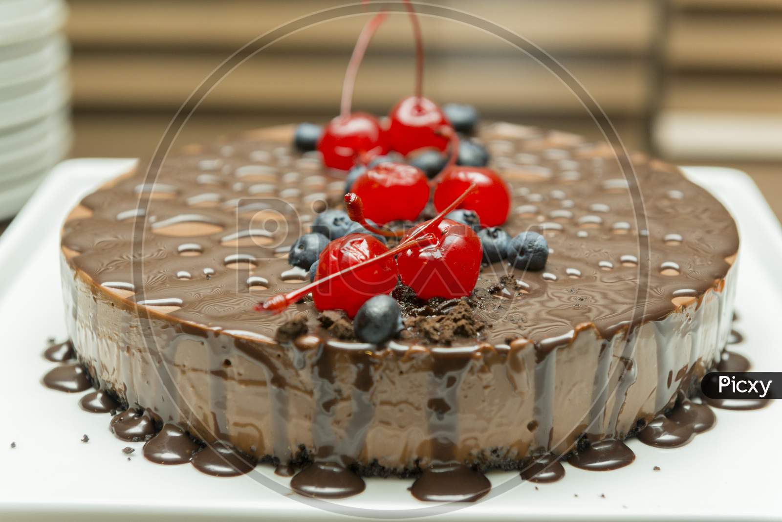 Beautiful And Tasty Chocolate Dessert, With Syrup And Cherry And Blueberry Topping.