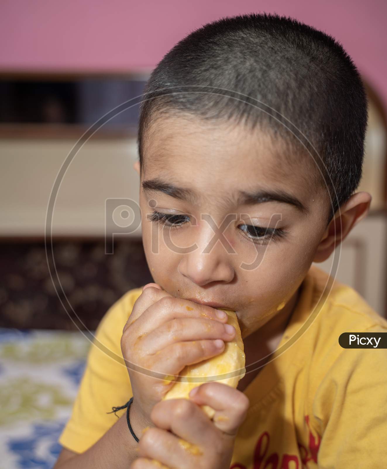 jaipur . Rajasthan . India - June 12, 2020. Happy little boy eating mango(lockdown activities)