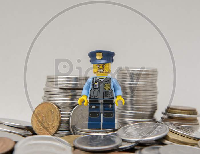 Minifigure Of Policeman On A Pile Of Coins.