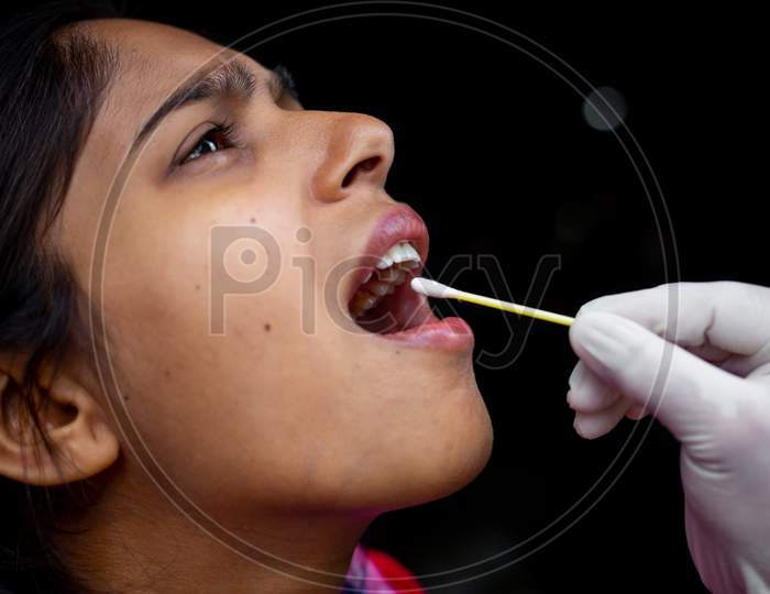 Doctor'S Hand Taking Saliva Test From Young Woman'S Mouth With Cotton Swab. Coronavirus Throat Sample Collection. Close-Up Views.