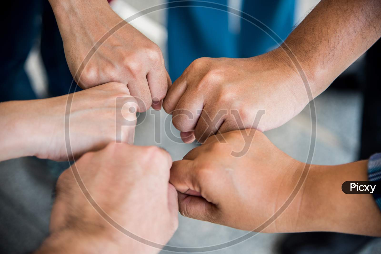 Close Up Top View Of Young People Doing Fist Bump By Hands Together. People And Business Concept. Unity And Teamwork Theme.