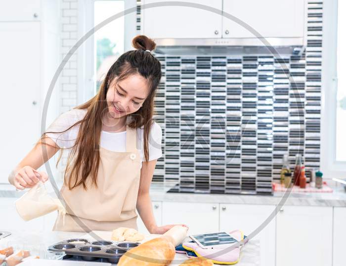Asian Woman Cooking And Baking Cake In Kitchen Alone Happily. People And Lifestyles Concept. Food And Drink Theme. Interior Decoration Theme.