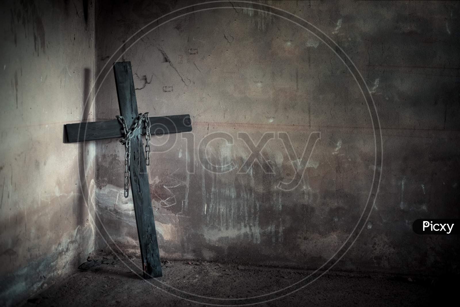 Black Cross Against Wall With Hanging Steel Chain And Gun. Halloween Day Party Festival Celebration. Ancient Sign Of Religion. Dark And Scary Tone
