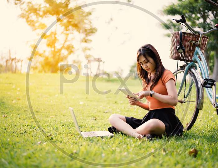 Woman Using The Tablet And Laptop In The Park, Outdoor Concept, Relax Concept, Technology Concept