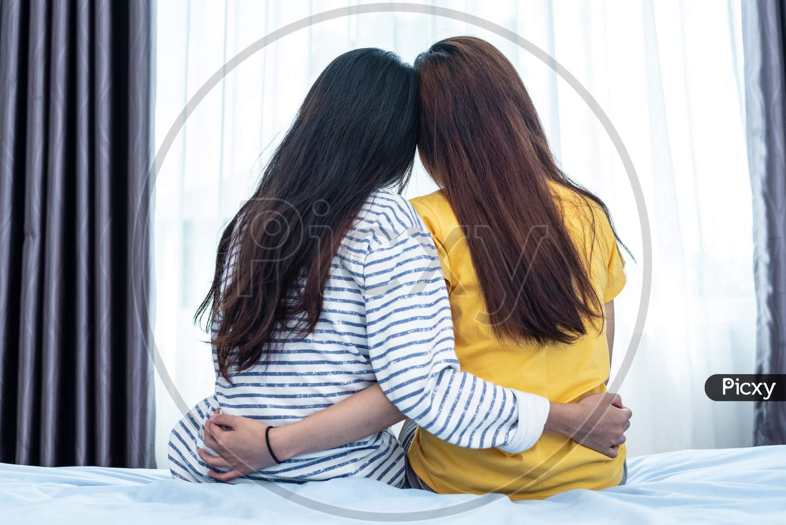 Back View Of Asian Beauty Embracing Together By A Girl Friend. People And Lifestyle Concept. Relationship And Friendship Theme. Lesbian And Lgbt Pride Theme.