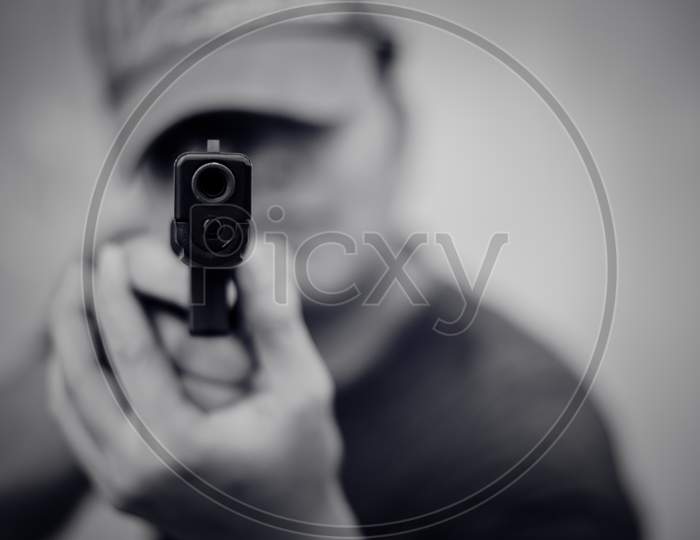 Man Aiming Gun And Ready To Shoot On Front View. People And Dangerous Weapons Concept. Criminal And Security Theme. Police And Robber Theme. Outlaw And Murderer Theme.