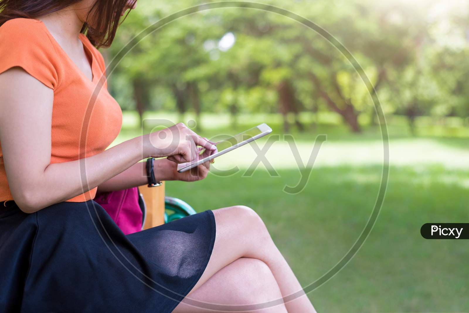Beauty Woman Using Tablet In The Park. Technology And Lifestyles Concept. Outdoor And Nature Theme.