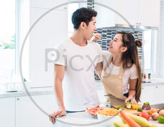 Asian Lovers Feeding Fruit And Food To Each Other, Couple And Family Concept. Sweet Honeymoon And Holidays Theme. Holiday And Indoor Interior