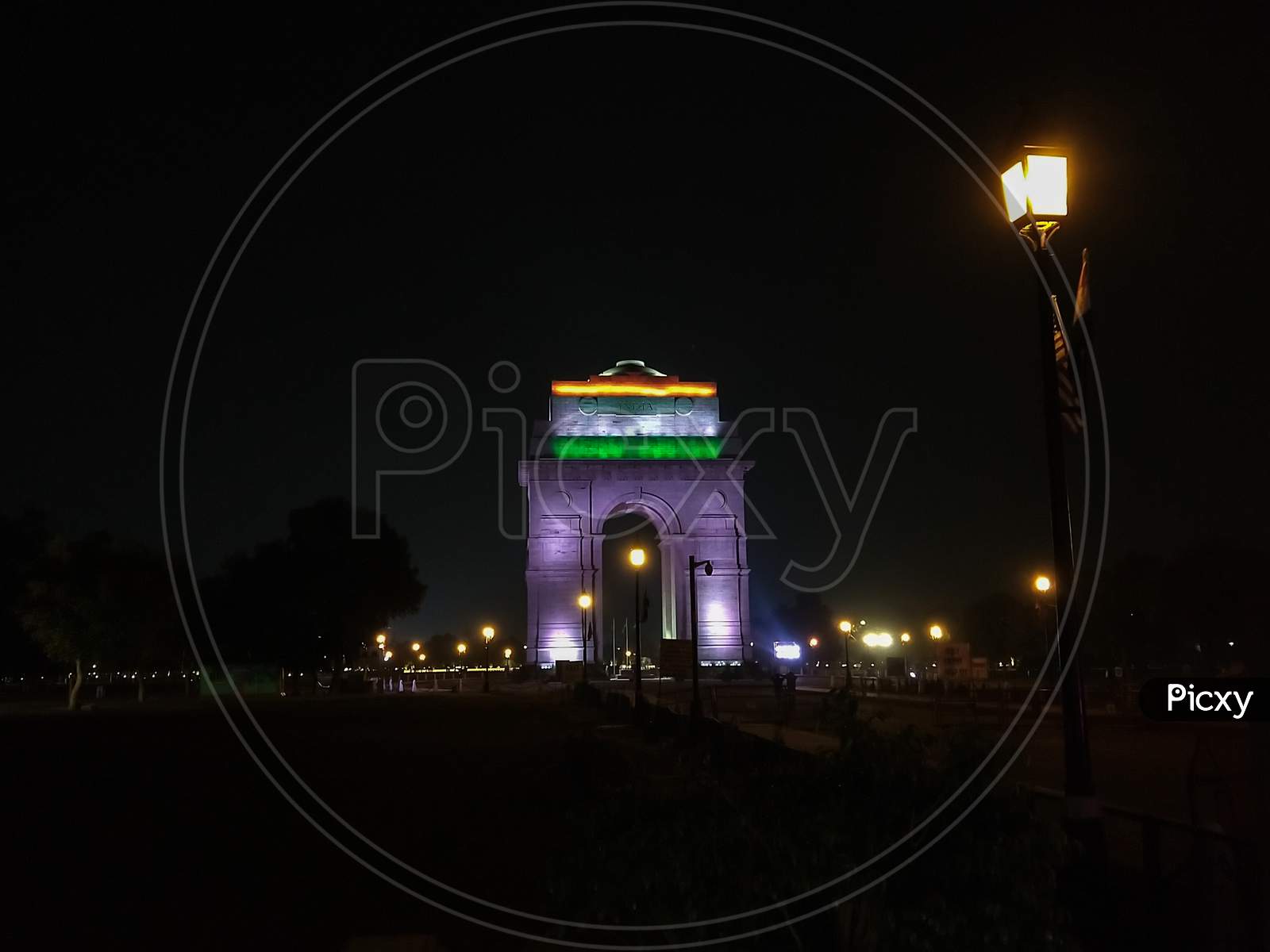 India Gate, Delhi, India- February 25, 2020: Night View Of India Gate From Outside Of Boundary. Indian National Flag Projected On India Gate
