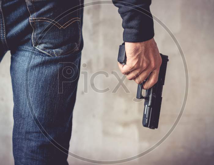 Close Up Of Man Holding Hand Gun. Man Wearing Blue Jeans. Terrorist And Robber Concept. Police And Soldier Concept. Weapon Theme