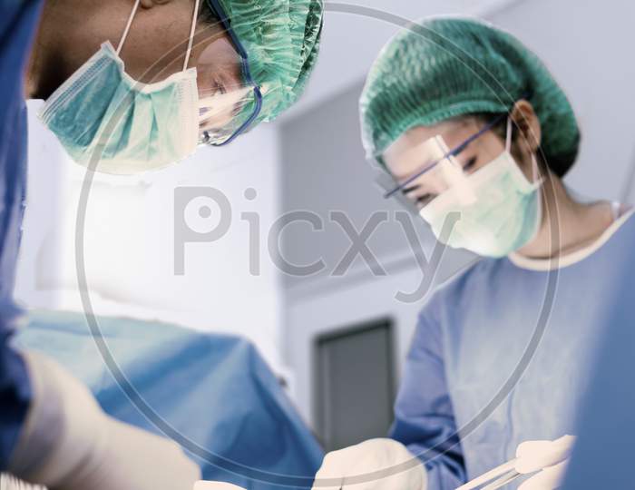 Doctors And Nurse Making Surgery In Operation Room. Health Care And Hospital Concept