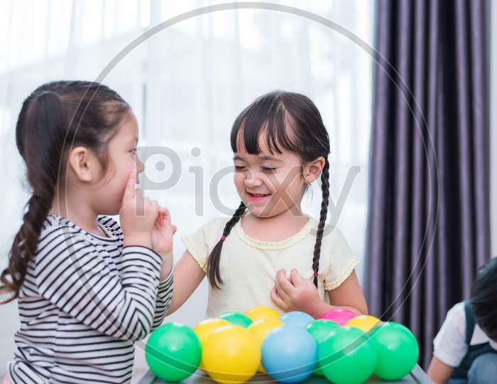 Two Little Girls And Boy Playing Small Toy Balls In Home Together. Education And Happiness Lifestyle Concept. Funny Learning And Children Development Theme. Smile Faces