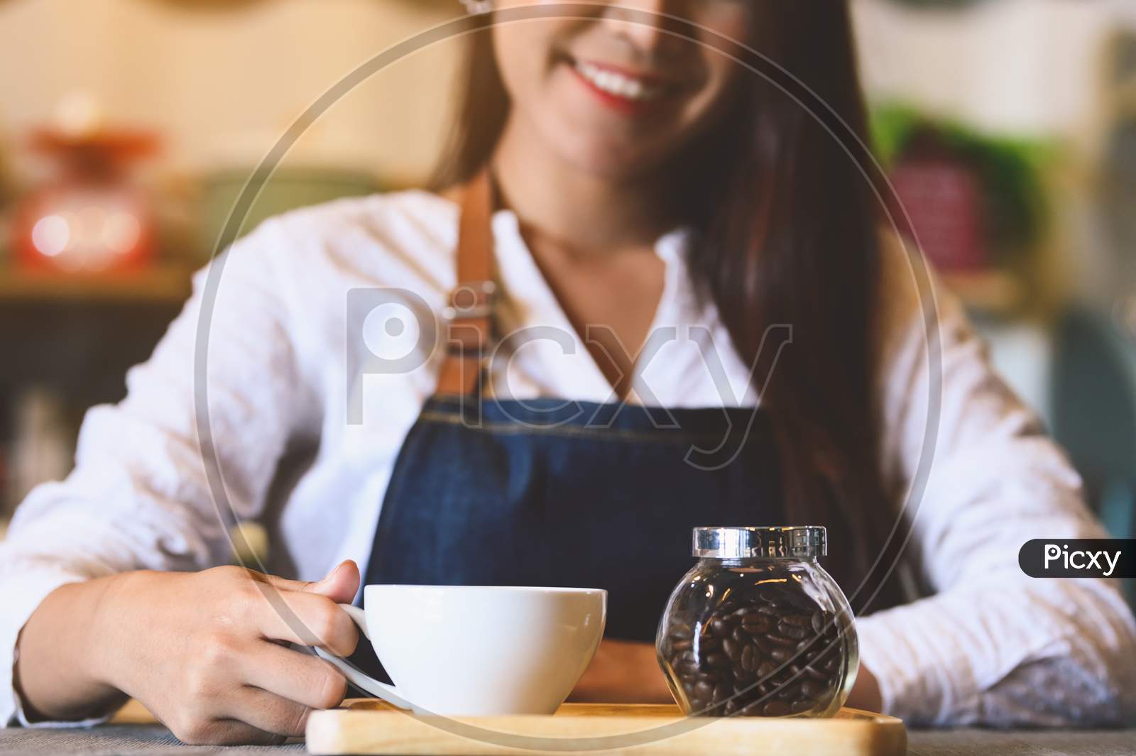 Closeup Of White Coffee Cup With Beautiful Asian Woman Barista Background For Serving To Customer. Job And Occupation. Food And Drink Beverage. Coffee Shop And Cafe. Business And Restaurant Ownership