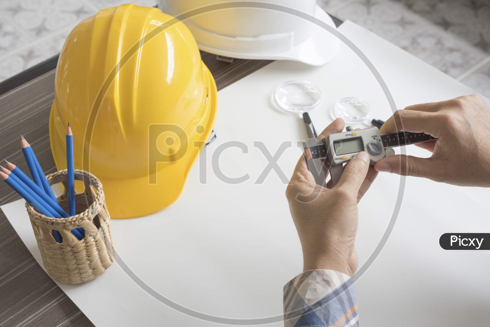 Construction Engineer Measuring With Vernier Caliper. Business And Technology Concept. Safety Helmet And Drawing Paper Elements. Civil And Drawing Sketch Theme.