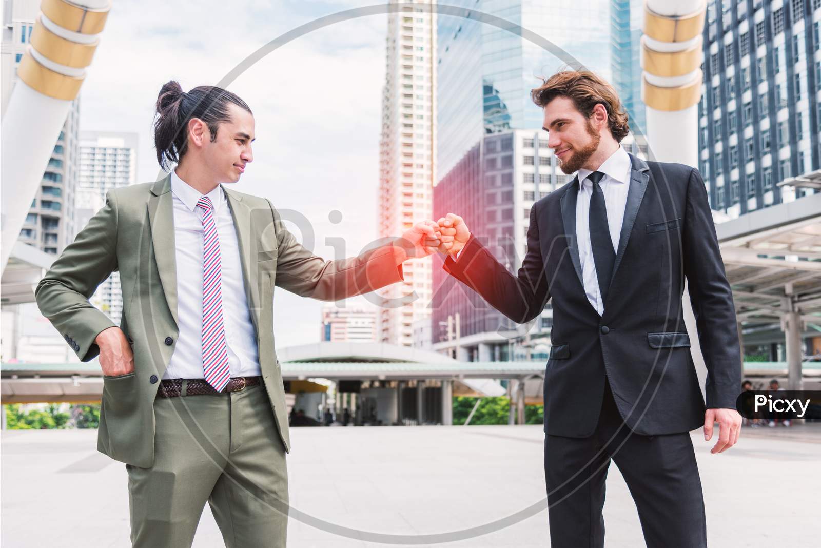 Fist Bump Or Knuckle Bump Between Two Businessmen Agreement At Outdoor In The City, Business Cooperation And Participation Concept, Power Of Teamwork Or Teammate