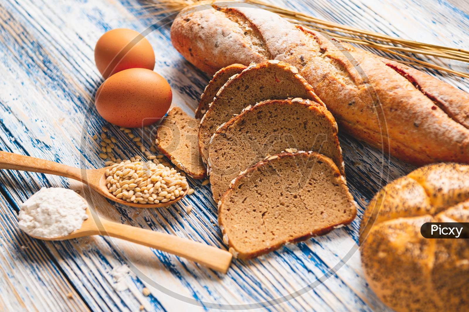 Different Kinds Of Bread With Nutrition Whole Grains On Wooden Background. Food And Bakery In Kitchen Concept. Delicious Breakfast Gouemet And Meal. Carbohydrate Organic Food Cuisine Homemade