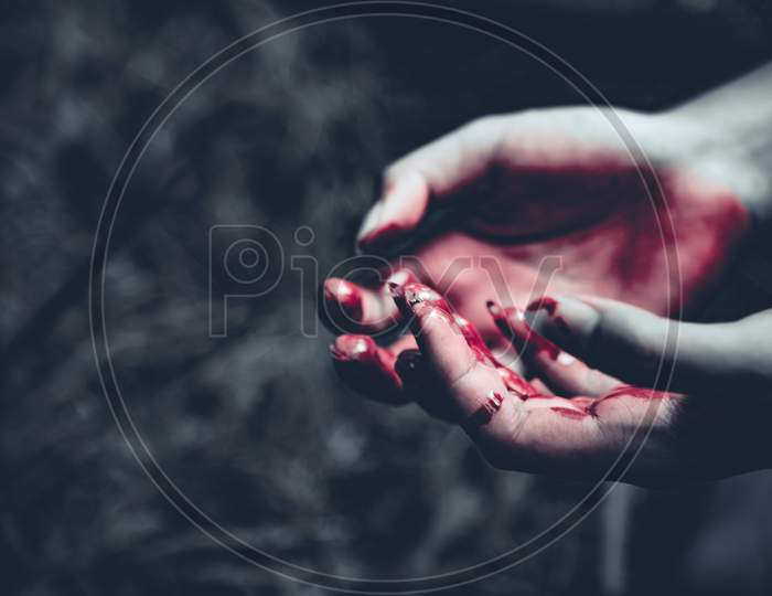 Close Up Of Bloody Hands In Dark Forest Background. Horror And Ghost Concept. Criminal And Murder Concept. Halloween Day And Sacrifice Theme. People And Religion Theme. Open The Palm Of The Hands.