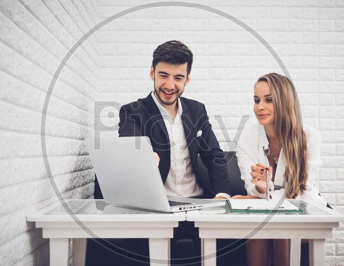 Businessman And Business Woman Analyzing Income Charts And Graphs In Coffee Shop. Business Analysis And Strategy Concept. Indoors Office Theme.
