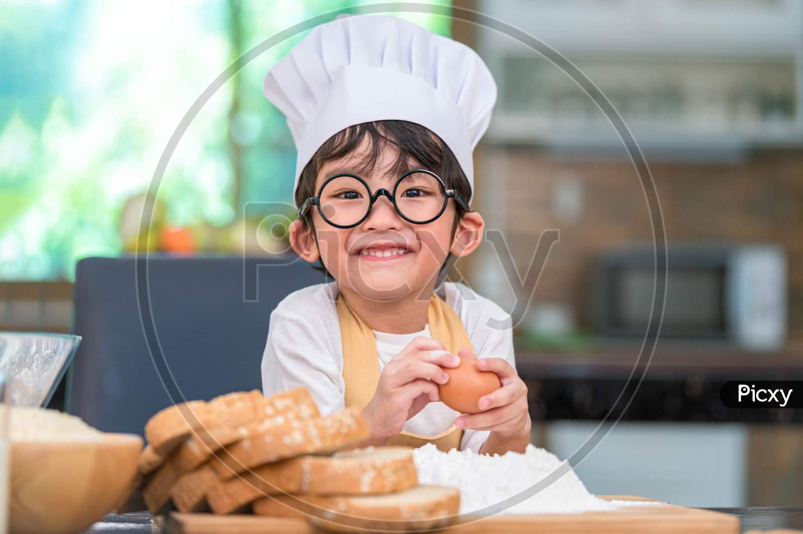 Portrait Cute Little Asian Happy Boy Interested In Cooking Funny In Home Kitchen. People Lifestyles And Family. Homemade Food And Ingredients Concept. Baking Christmas Cake And Cookies. Smiling Child