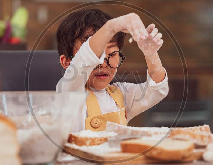 Portrait Cute Little Asian Happiness Boy Interested In Baking Bakery With Funny In Home Kitchen. People Lifestyles And Family. Homemade Food And Ingredients Concept. Baking Christmas Cake And Cookies