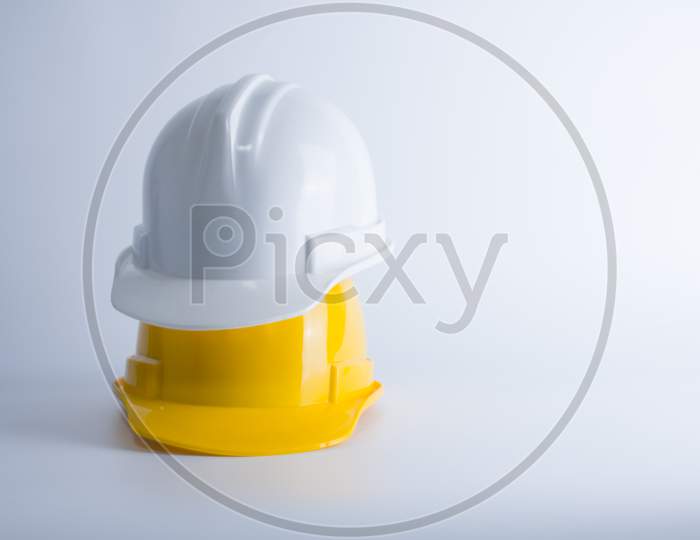 White And Yellow Safety Helmet On White Background. Hard Hat And Thick Gloves On White Isolated Background. Safety Equipment Concept. Worker And Industrial Theme.