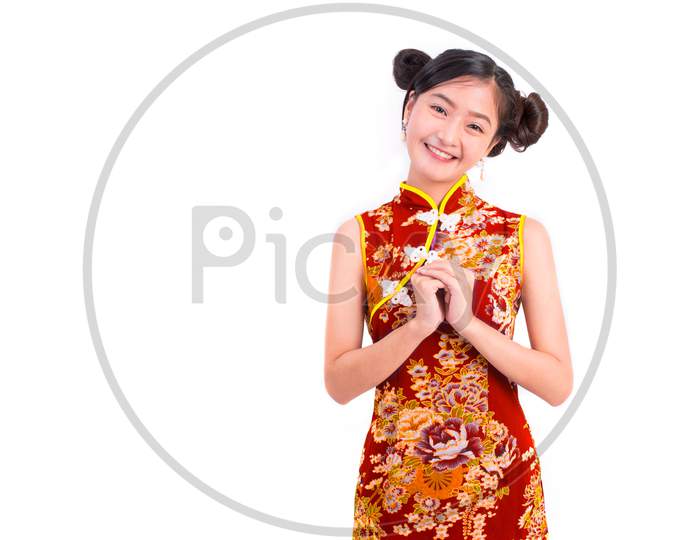 Young Asian Beauty Woman Wearing Cheongsam And Blessing Or Greeting Gesture In Chinese New Year Festival Event On Isolated White Background. Holiday And Lifestyle Concept. Qipao Dress Wearing