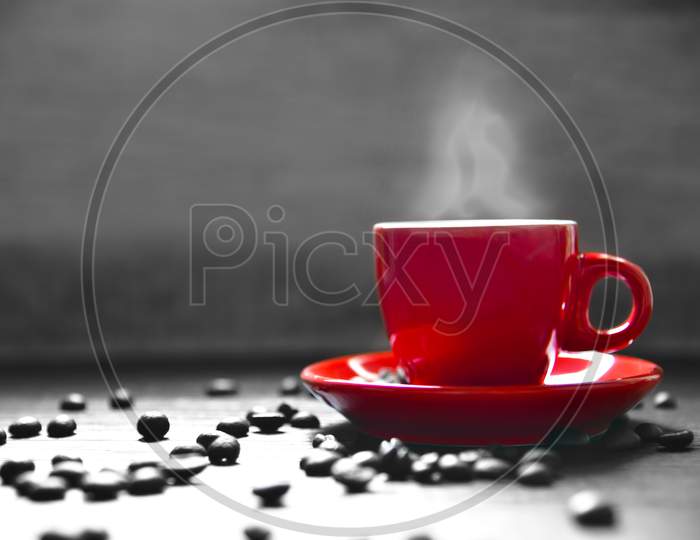Red Cup Coffee With Smoke And Coffee Bean On Wood Table, Drinking Concept, Selective Red Color