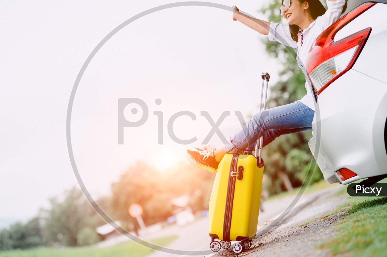 Happy Asian Woman Spread Arms Widely And Breathed Fresh Air With Happiness Mood In On Road Trip In Car Trunk. People Lifestyle In Long Vacation Trip Concept. Outdoors Nature And Transportation
