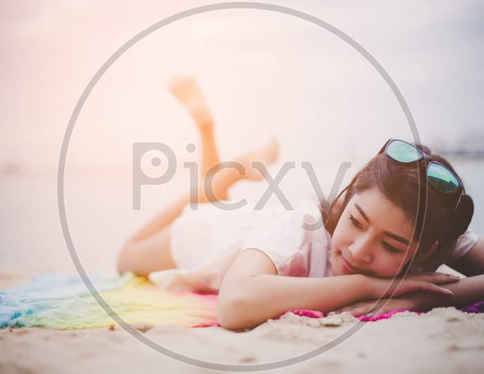 Beauty Asian Woman Have Vacation On Beach. Girl Wearing Sunglasses And Lying On Colorful Mat Near Sea. Lifestyle And Happy Life Concept.  Travel And Holiday Theme. Summer And Tropical Theme.