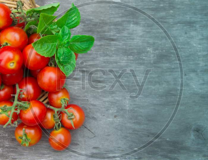 Fresh Cherry Tomatoes Basil And Oregano On Aged Wooden Rustic Background
