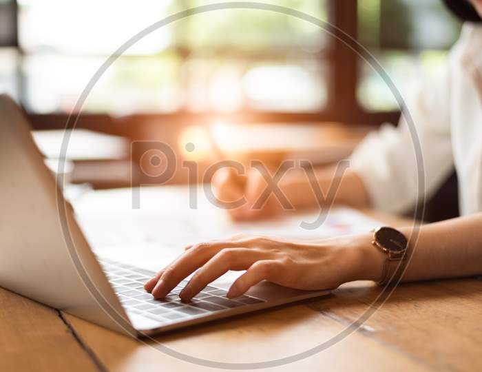 Close Up Of Woman Typing Keyboard On Laptop In Coffee Shop. People And Technology Concept. Freelance And Lifestyle Theme. Entrepreneur And Working Outside Office Theme.
