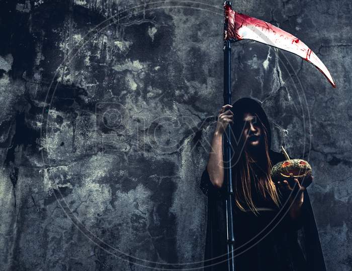 Demon Witch With Reaper On Grunge Wall Background. Halloween And Religious Concept. Demon Angel And Satan Theme.
