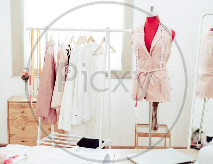 Fashion Designer Showroom Studio Workshop Background With New Collection Of Pink Pastel Female Clothing Design. Tailor And Sewing Concept. Dressmaker Modern Room Interior Red With Mannequin