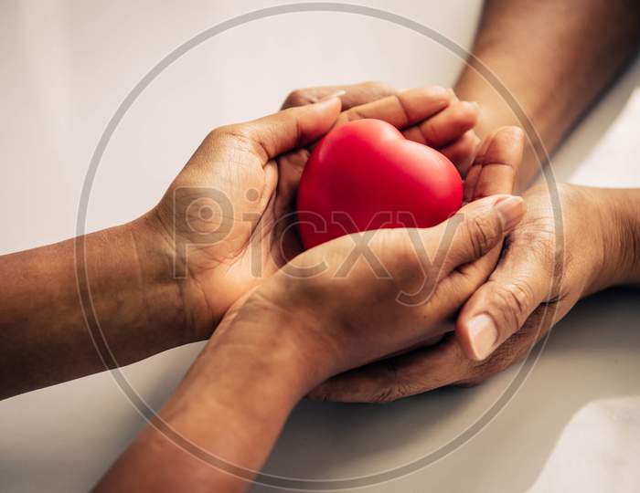 Helping Hand Of Heart Donor For Patient In Heart Disease. Man Give Red Heart To Woman As Couple. People Lifestyle And Couple Romance. Healthcare And Hospital Medical Concept. Symbolic Of Valentine Day