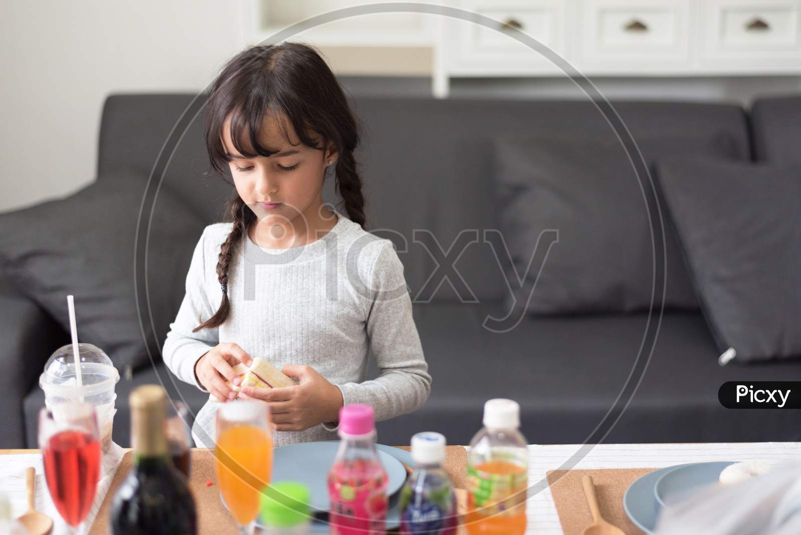Happy Little Girl Preparing To Cook With Toy As Chef In Living Room. Playful Of Child And Happiness Education And Development Concept. Learning And Leisure Of Cute Girl. Nursery And Daycare Theme.