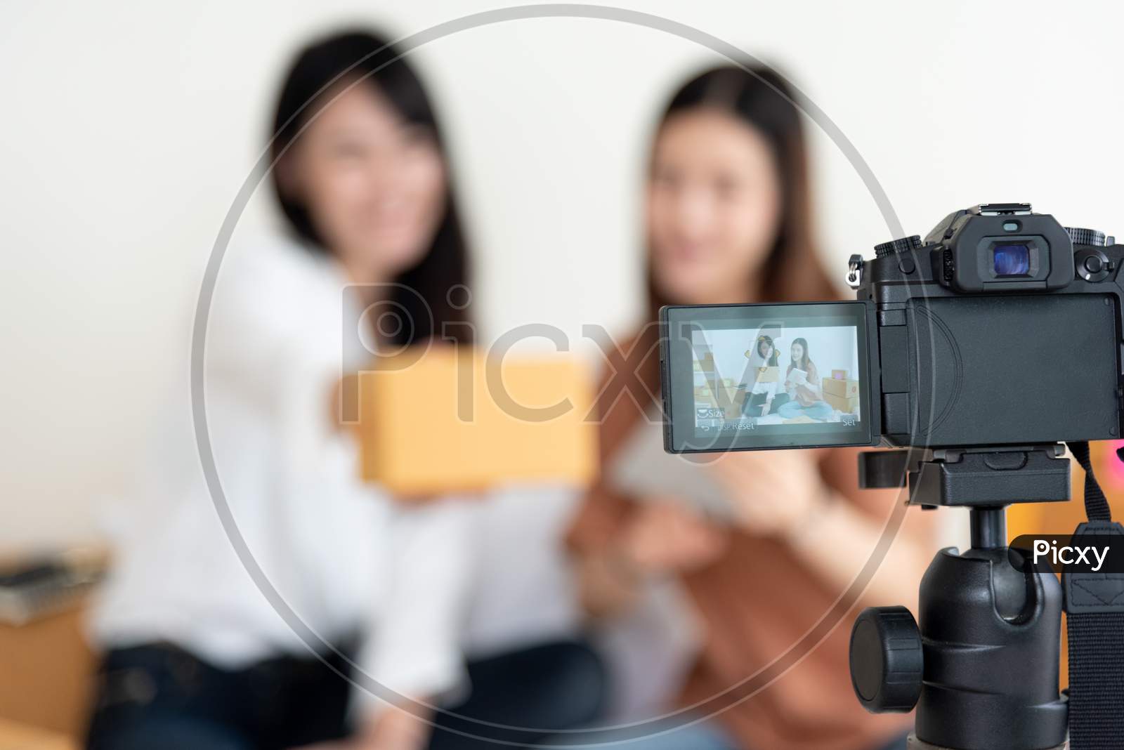 Closeup Of Digital Video Camera Recording Two Girls Presenting New Product Advertisement. Vlog And Influencer Concept. People Part Time Job And Occupation. Young Teenagers Using Modern Technology
