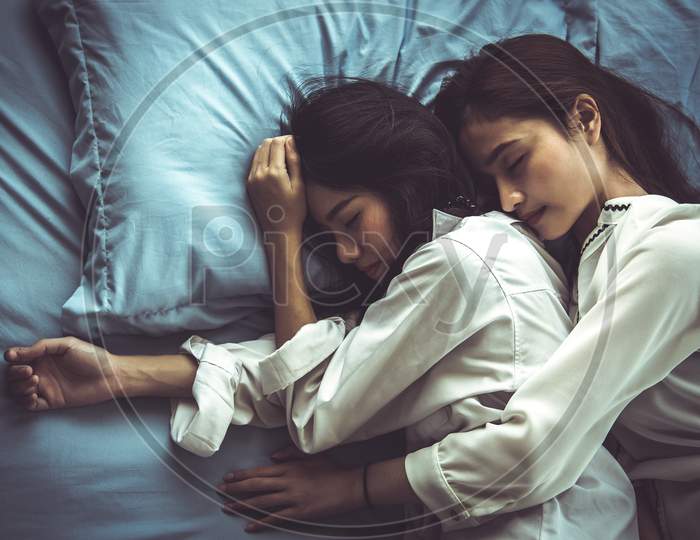 Top View Of Two Asian Women Sleeping On Bed Together. Lesbian Lovers And Couple Concept. People And Lifestyles Theme.