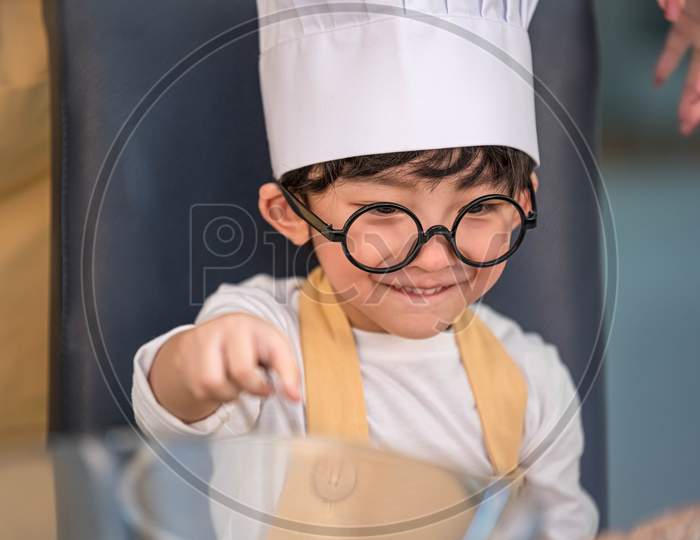 Portrait Cute Little Asian Happy Boy Interested In Cooking With Mother Funny In Home Kitchen. People Lifestyles And Family. Homemade Food And Ingredients Concept. Baking Christmas Cake And Cookies
