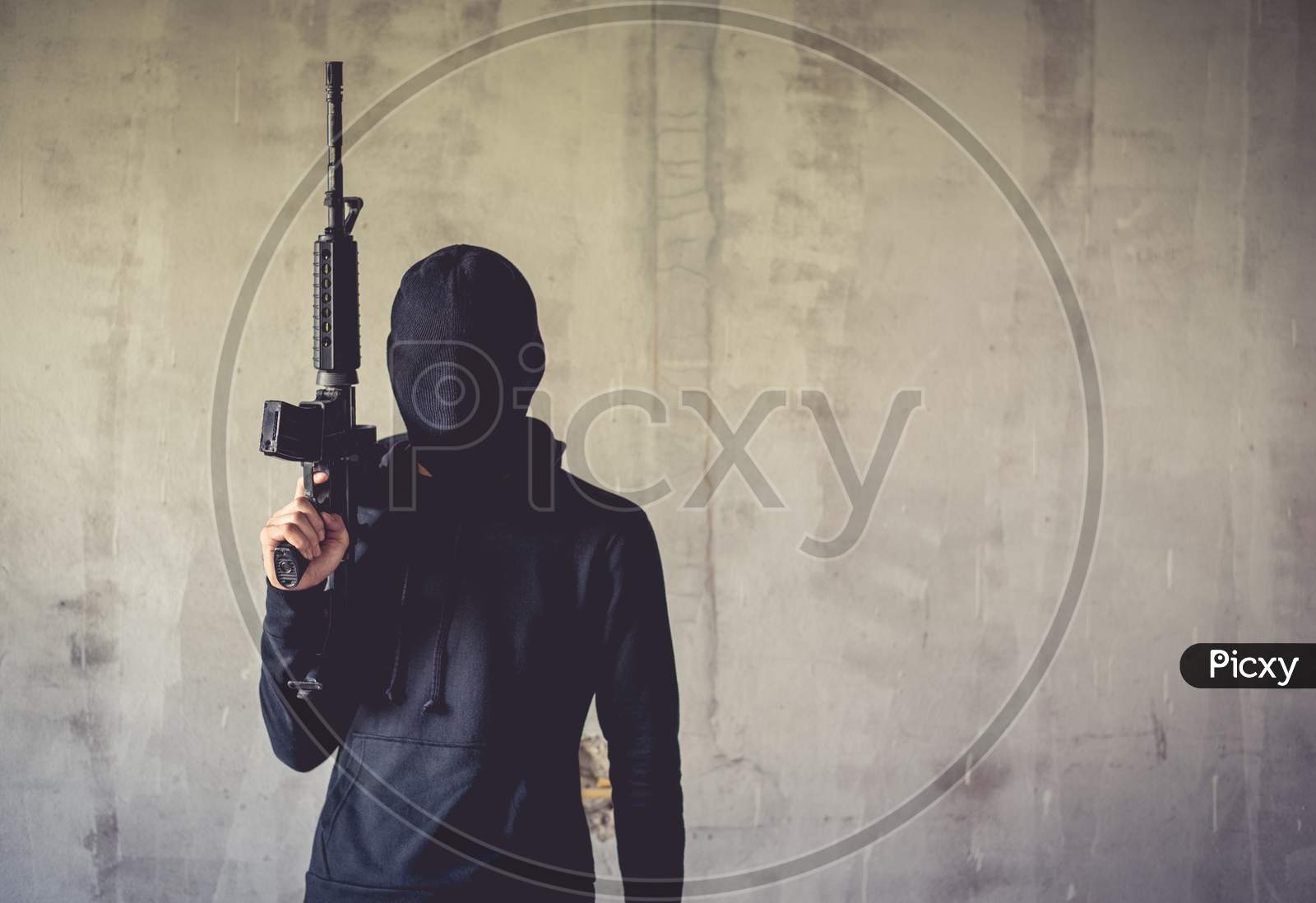 Terrorist Holding Rifle Gun On Grunge Wall. Social Issued Theme. Terrorist And Robber Concept. Police And Soldier Theme. Social Issued Theme.