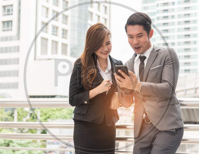Two Businessman And Woman Enjoy Using Mobile Phone. Relax Time And Happiness Concept.
