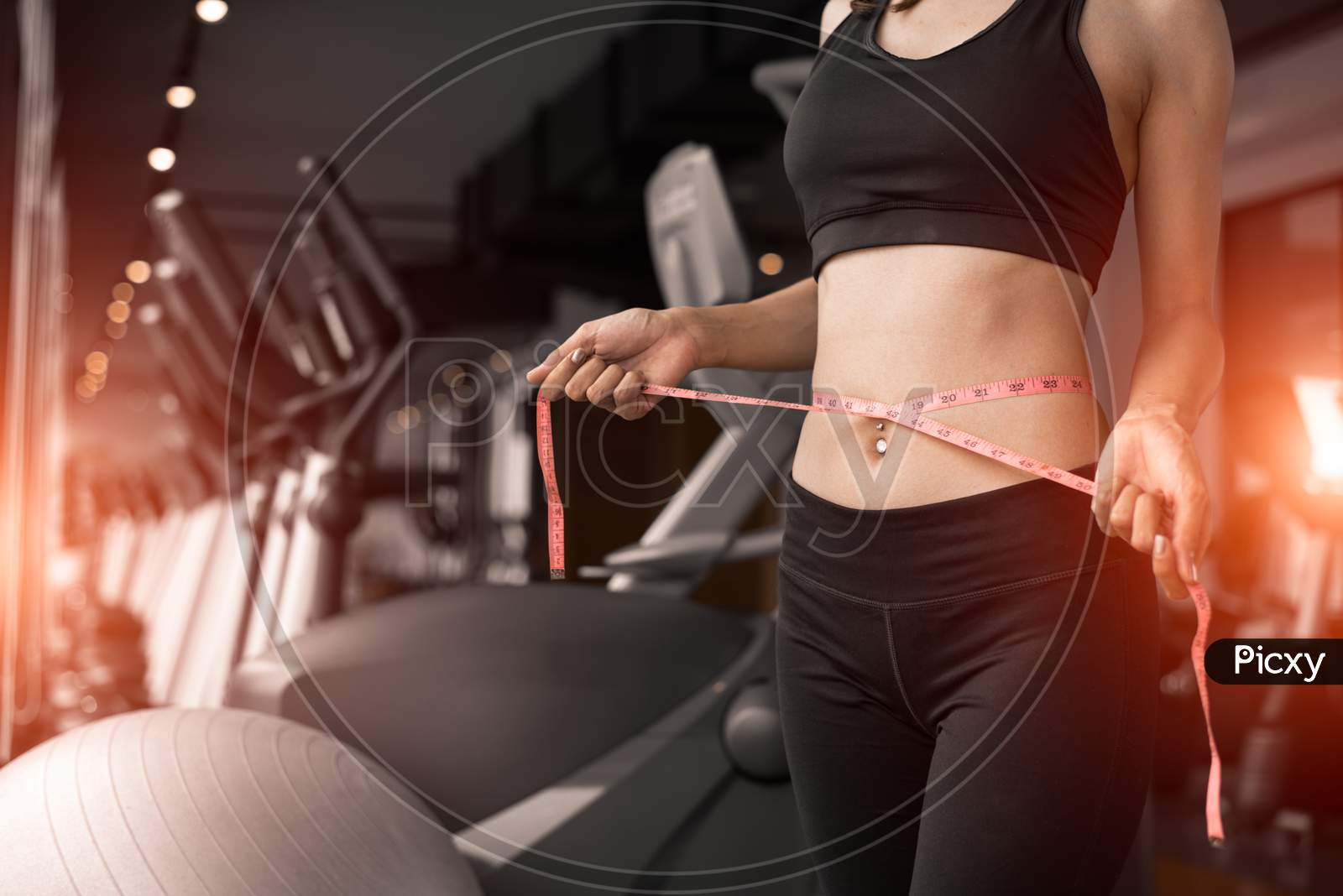 Sporty Woman Using Waist Tape Line In Fitness Gym Sport Club Training Center Near Window With Condominium Background. Lifestyle Of People Workout Exercise Sport Activity. Diet And Weight Loss Theme.