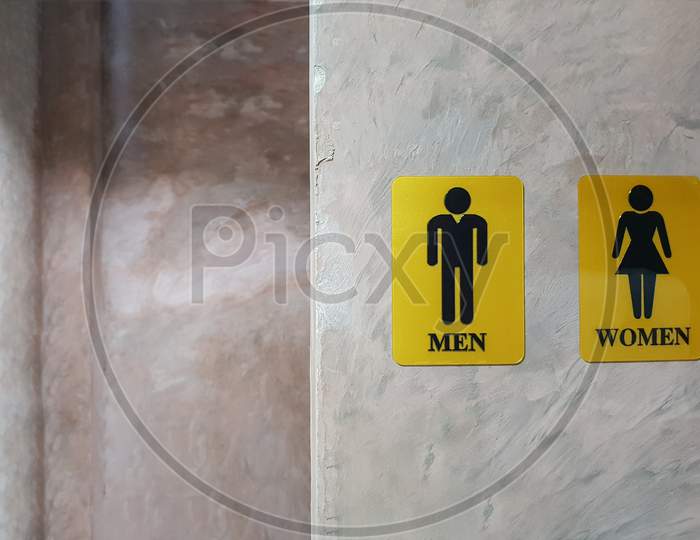 Public Toilet Of Men And Women. Sign Of Lady And Gentleman Washroom Called Wc. Mixed Gender Symbol Toilet And Restroom Behind Concrete Wall Decorate By Vintage Style In Department Store. Text Message