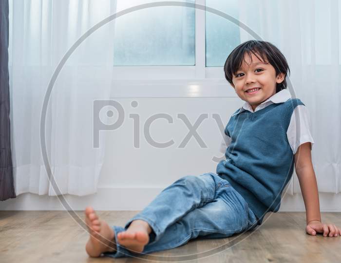 Happy Boy Sitting And Smiling In Bedroom. Lifestyles And People Concept. Portrait And Happiness Life Concept. Home Sweet Home Theme.