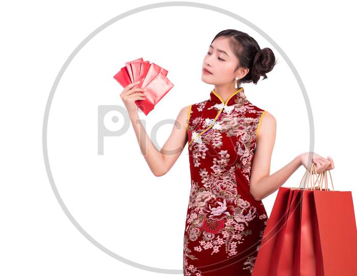 Young Asian Beauty Woman Wearing Cheongsam And Holding Moneys As Millionaire Gesture In Chinese New Year Festival Event On Isolated White Background. Holiday And Lifestyle Concept. Qipao Dress Wearing