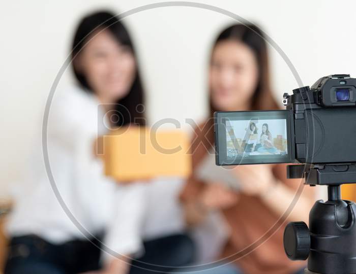 Closeup Of Digital Video Camera Recording Two Girls Presenting New Product Advertisement. Vlog And Influencer Concept. People Part Time Job And Occupation. Young Teenagers Using Modern Technology